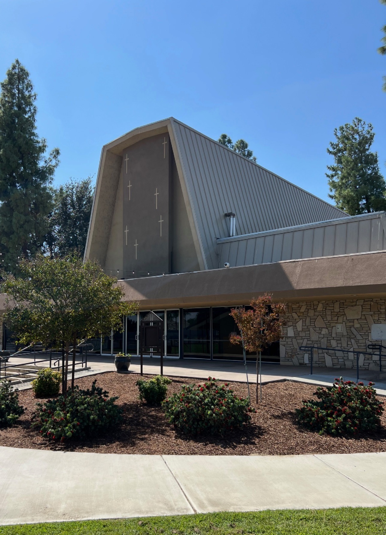 The A-frame sanctuary of Rosedale Bible Church with crosses on the front and a landscaped entry